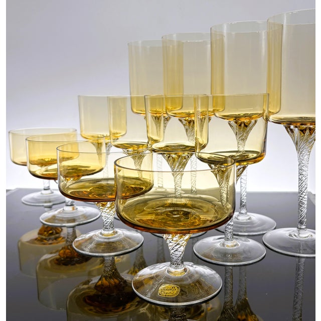 An elegant 12-piece Bohemia Crystal stemware service for four, made in Czechoslovakia and distinguished by warm amber...