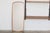 A slender vintage wall mirror with a distinctive, elongated shape and softly rounded corners. Its minimalist silhouette...