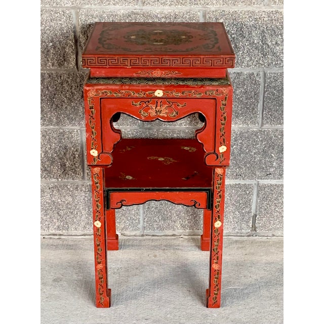 Fabulous vintage side table. Lacquered red with ornate detailing. Chinoiserie feel with Ming style legs. Perfect for a...
