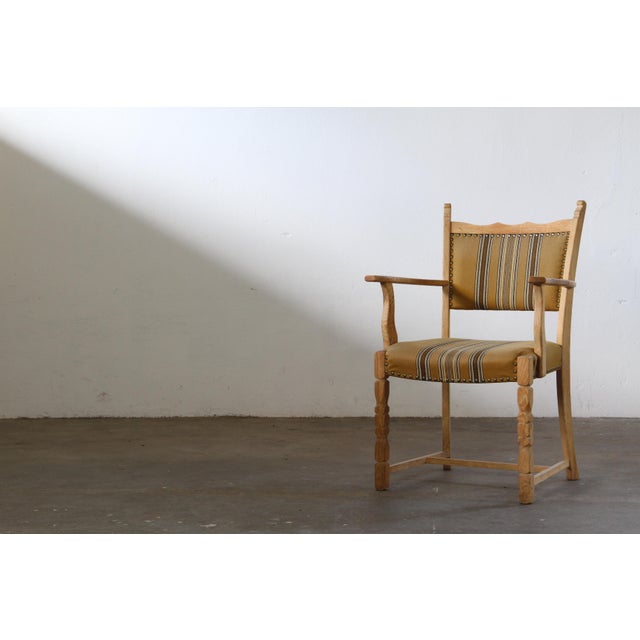 This oak armchair, executed in the unmistakable style of Henning Kjærnulf, commands attention with its bold brutalist...