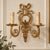 Bring the elegance of French decorative arts into your interior with this striking two-light wall sconce, featuring an...