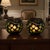 Pair of oversized vintage black glass globe candle holders featuring frosted green circular cutwork, polished reflective...