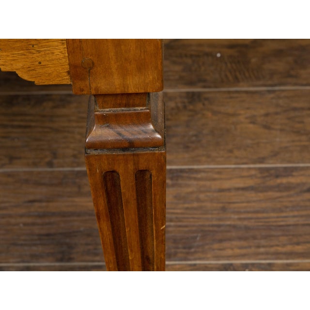 A French Louis XVI style walnut console table from the 19th century, with large single drawer, carved geometric motifs,...