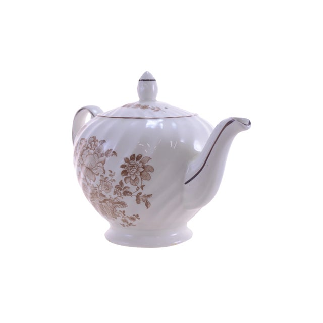 English Staffordshire ironstone lidded teapot with fluting swirled around the body and a floral pattern in brown on white....