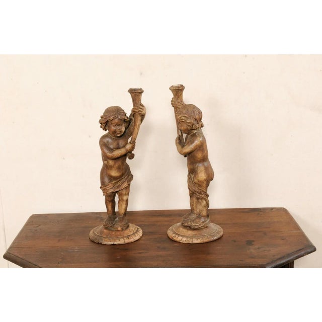 An Italian pair of carved wood putti decorations from the 19th century. This antique pair of candle holders from Italy,...