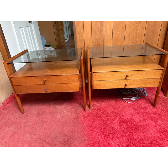 These 1960s Parallel by Drexel walnut side tables have glass tops and two drawers. The original glass tops highlight the...