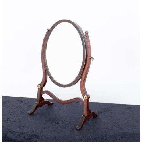Sheraton style mahogany oval toilet mirror Circa 1900 This mirror stands upon shaped feet with shaped supports and a...