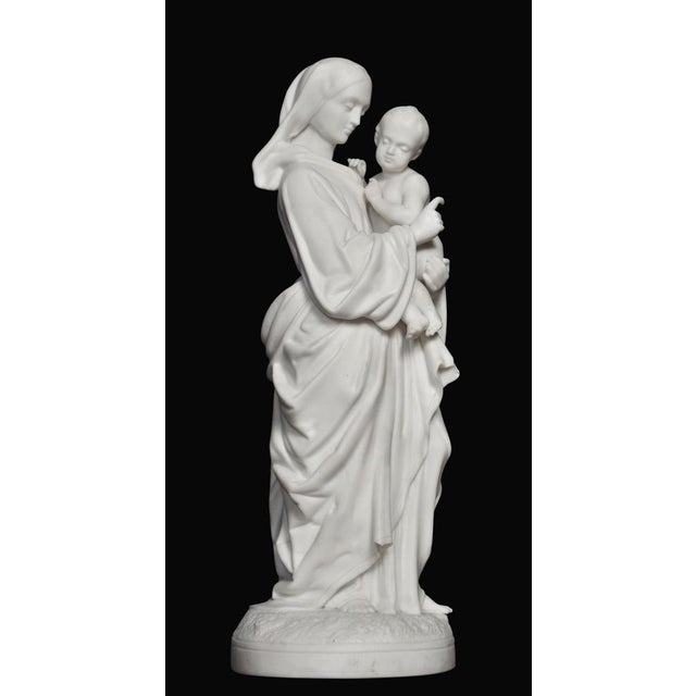 19th century Parianware figure of mother and child raised up on circular base. Dimensions Height 16 Inches Width 6 Inches...
