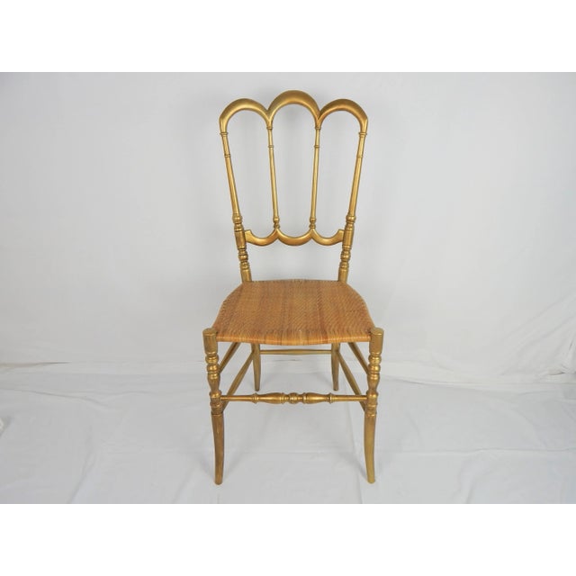 Vintage gilded wood Chiavari chair with woven seat. Condition: some wear to frame gilding, seat edge appears to have old...