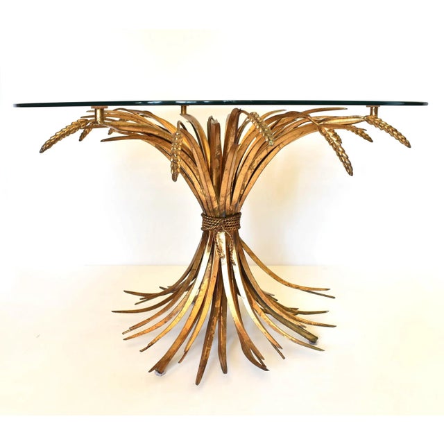 An Italian, mid-century "Sheaf of Wheat" table, featuring gold gilt metal wheat tied in a bundle, with a round glass top....