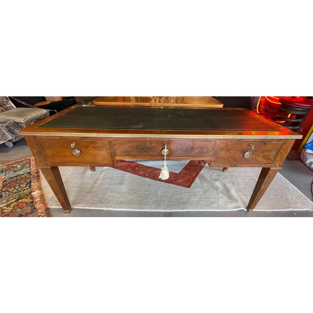 This is a splendid Louis XVI writing desk with intent leather top. Each end has a pull out shelf. The front is adorned...
