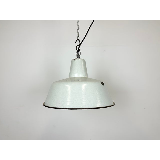 Industrial dark white (light grey) enamel pendant light made by Zaos in Poland during the 1960s. White enamel inside the...