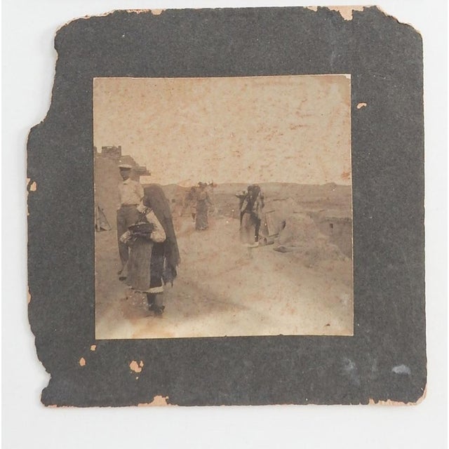 Early 20th century silver gelatin photograph of a Native American Pueblo with native woman and man and woman visitors....