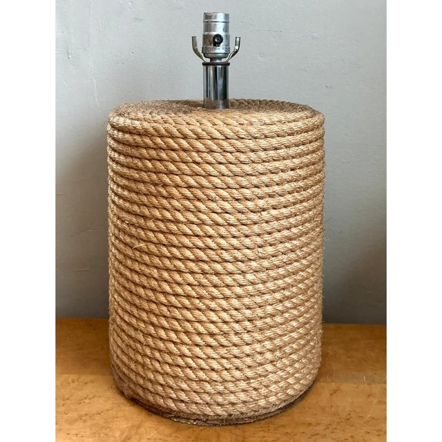 This vintage table lamp is a study in texture, built as a bold cylinder wrapped in thick, twisted natural rope. The coils...