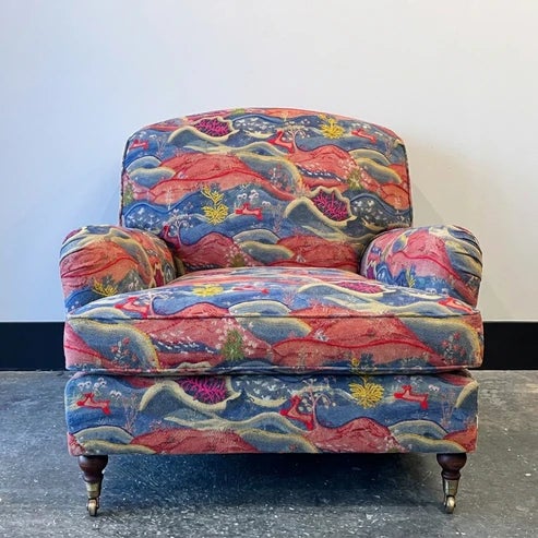 Club chair upholstered in Andrew Martin Meadow Multi Fabric. Part of the Kit Kemp Collection. Front Casters on Turned Wood...