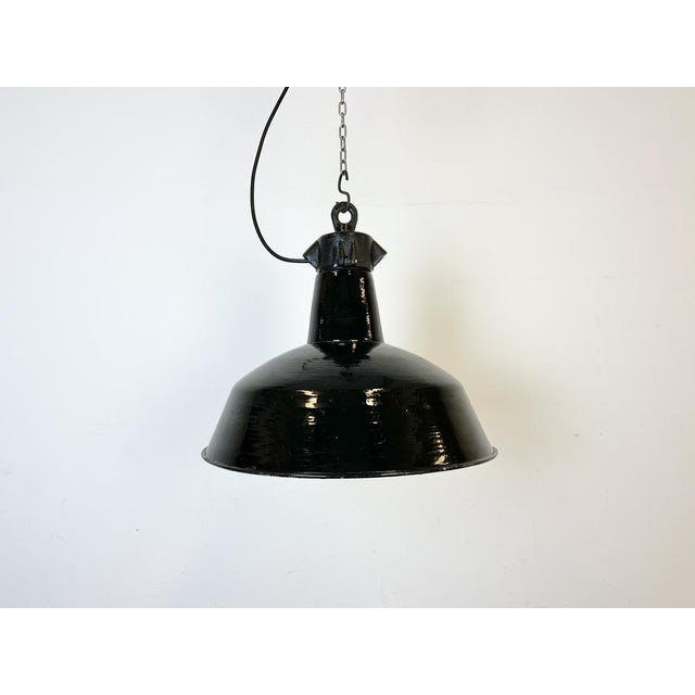 Industrial black enamel pendant light made by Elektrosvit in former Czechoslovakia during the 1950s. White enamel inside...