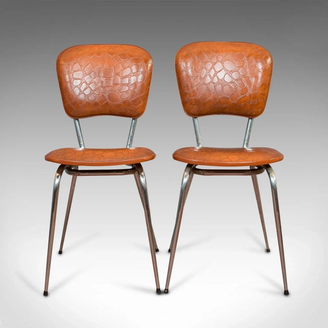 This is a pair of vintage chairs. A French, faux crocodile upholstered desk or breakfast chair, dating to the mid-20th...