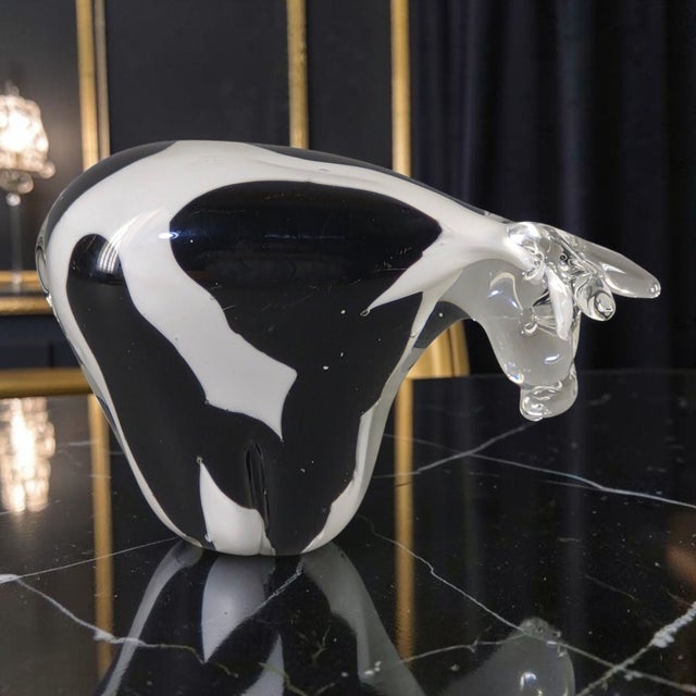 This Italian hand-blown art glass figurine features a black and white spotted cow design, adding a decorative touch to any...