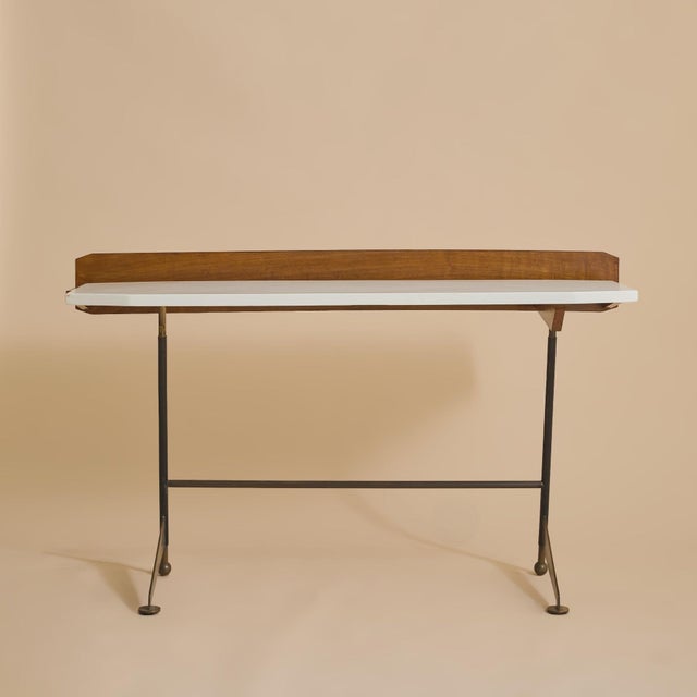 An Italian console or desk executed in the manner of Luigi Fornasari, from the 1950s. The streamlined rectangular top is...