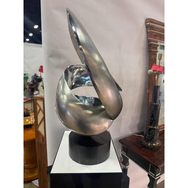 Bold, sophisticated, and visually dynamic, this large modern abstract sculpture is crafted from beautifully polished steel...