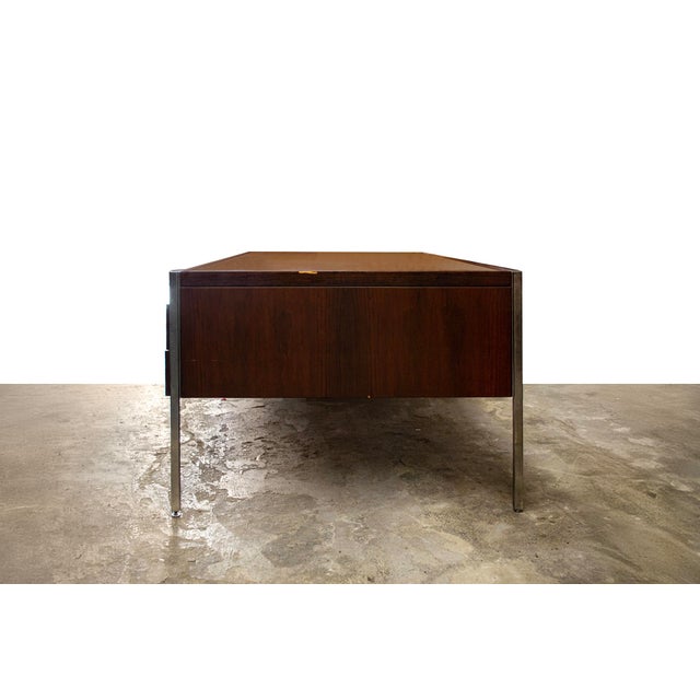 Large six-drawer center desk with rosewood frame and chromed steel legs. Designer Florence Knoll Bassett Manufacturer...