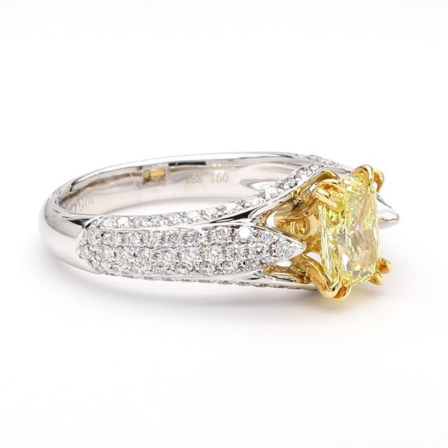 GIA Certified 1.01 carat Fancy Intense Yellow radiant cut diamond set in an 18K yellow gold double-prong basket with 0.65...