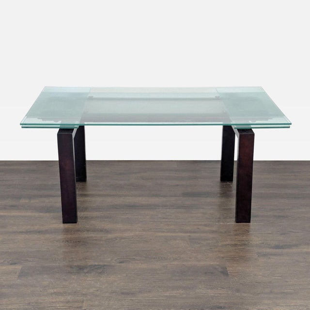 Glass top with wood legs. When extended, the table expands to 105 inches. Dimensions (in): 67W x 40D x 30H.