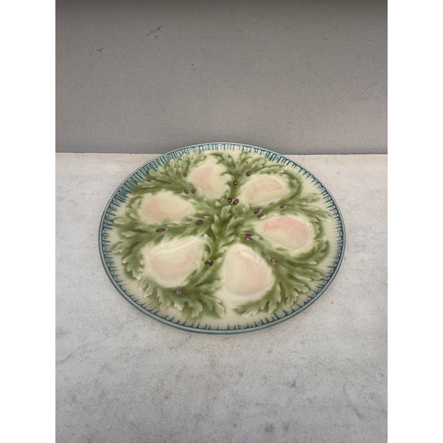 French Majolica oyster plate signed Hippolyte Boulenger Choisy-le-Roi. The six pink wells are surrounded by green seaweeds.