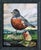 Delicate Feast presents a whimsical scene where a plump robin stands prominently, juxtaposed with a vibrant caterpillar...