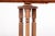 A carved wooden music stand in a warm honey-brown finish with a natural wood grain, an open triple turned columnar frame,...