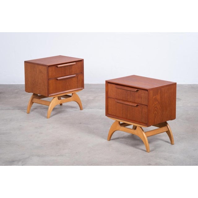 Elegant pair of bedside tables produced in Denmark during the 1960s. Crafted with teak cabinets and solid oak frames, the...