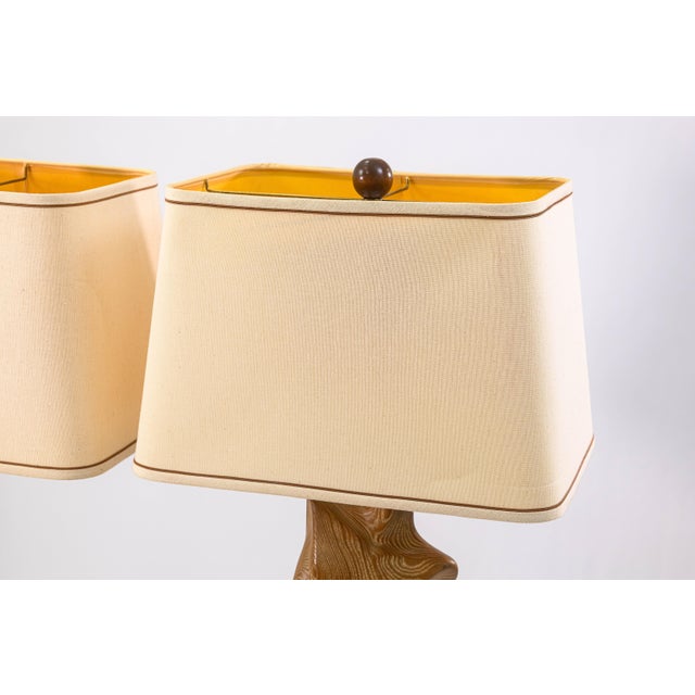 A pair of Yasha Heifetz torso table lamps. This vintage pair of table lamps feature a sculptural set of wooden torsos of a...