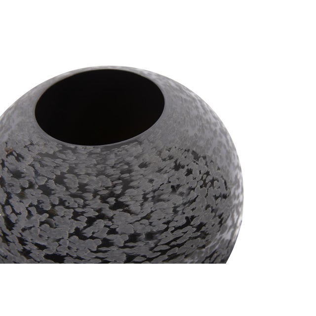 This interesting vase features a glossy black, globe shape formed from iron. What makes it unique, is the chiseled texture...