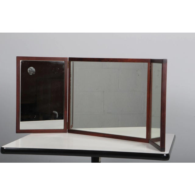 Aksel kjersgaard. Foldable all mirror in rosewood, denmark, 1960s. Measures: h. 43 w. 58/116 d. 45. This piece is...