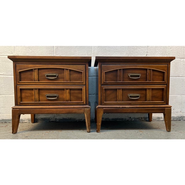 This is a pair of vintage Dixie Furniture nightstands in a Mid-Century Italian Tuscan style, featuring a stained walnut...