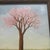 This charming mid-century landscape painting captures the serene beauty of spring, centering on a lone, stylized pink...