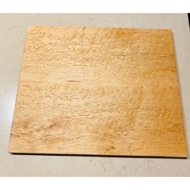 A rare "Bird's Eye Primo Maple" cutting board by Ed Wohl, crafted from Primo bird’s eye maple, sculpted riser platform,...