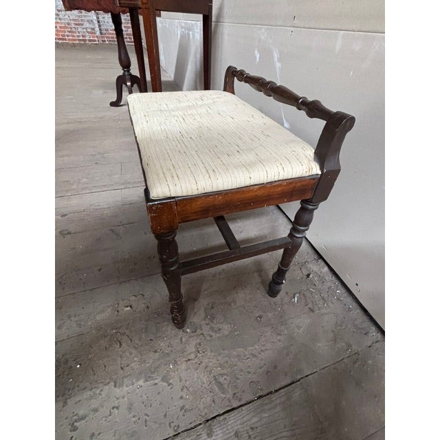 Antique boudoir bench of carved walnut. Manufactured in the 1920's by Crocker Chair Company in Sheboygan, Wisconsin. It...