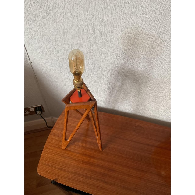 Mid-Century isosceles triangle style tripod which has been hand crafted to perfection. The teak wooden legs are fixed to a...