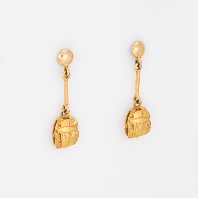 Charming pair of vintage Egyptian scarab earrings crafted in 14k yellow gold. Featuring stylized scarab motifs suspended...