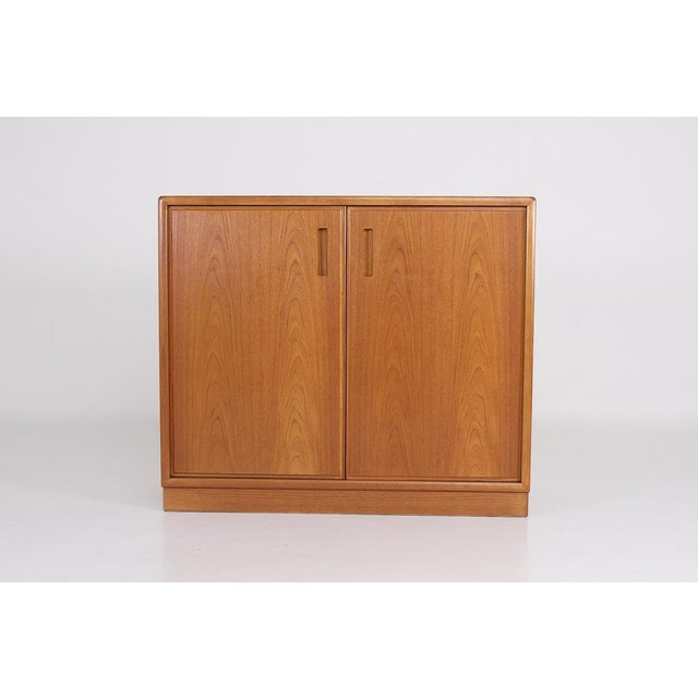 Teak sideboard with two doors, on a solid base. Scandinavian design, 1970s. H 81 cm x D 42 cm x W 94 cm. Usable depth 36...