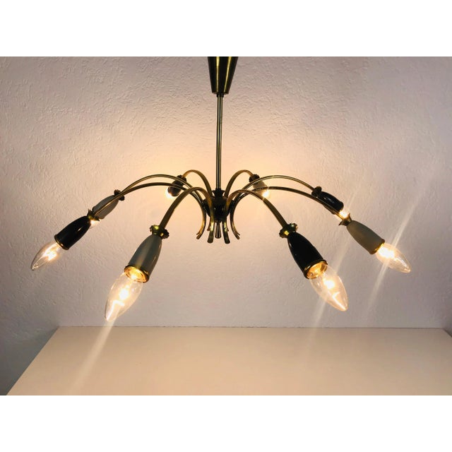 A sputnik chandelier made in germany in the 1950s. It is fascinating with its eight brass arms, each of it with an e14...