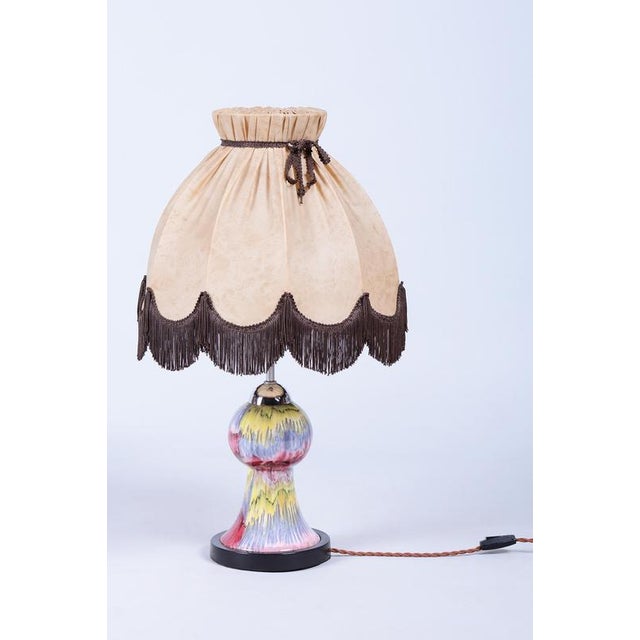 This decorative table lamp dates back to the 1960s and represents a striking example of Czechoslovak "Mid-Century"...