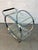 Striking Mid-Century Modern glass and chrome bar cart designed by George Mulhauser for DIA, featuring a sculptural...