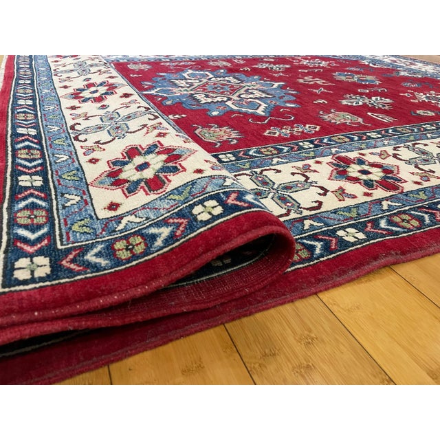 Infuse your space with the bold spirit and timeless artistry of the Caucasus. This exceptional Kazak rug is more than just...