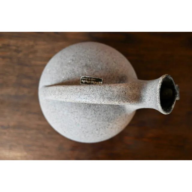 Original by its lying shape and by the grainy treatment of its enamel, this pretty Accolay pitcher is an original...