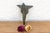A robust utilitarian antiquity featuring a detailed geometric stem and a stylized architectural bud finial, carrying a...