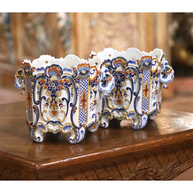 Highly decorative and richly colored, this pair of antique faience cachepots displays the exuberant ornament associated...