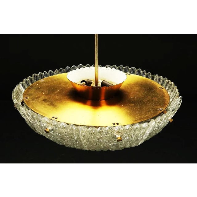 Bowl form brass frame fitted with eight E27 and 3 E14 sockets and heavy crystal glasses made by Orrefors in the early...