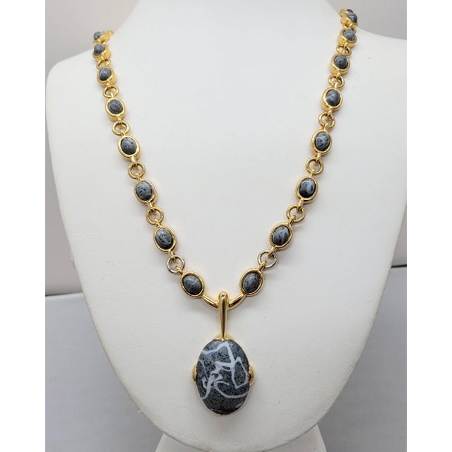 1960s goldtone grey cabochon rhinestone with white stripes, with smaller grey with speckles and stripes cabochons on the...